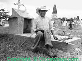 Mexican gravesite caretaker poses with machette