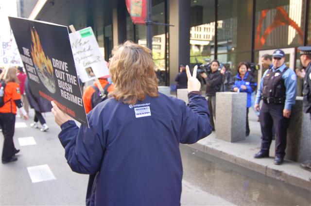 "V" sign from demonstrator toward police on antiwar march. Chicago