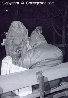 Homeless man sits on bench in Winter, Chicago